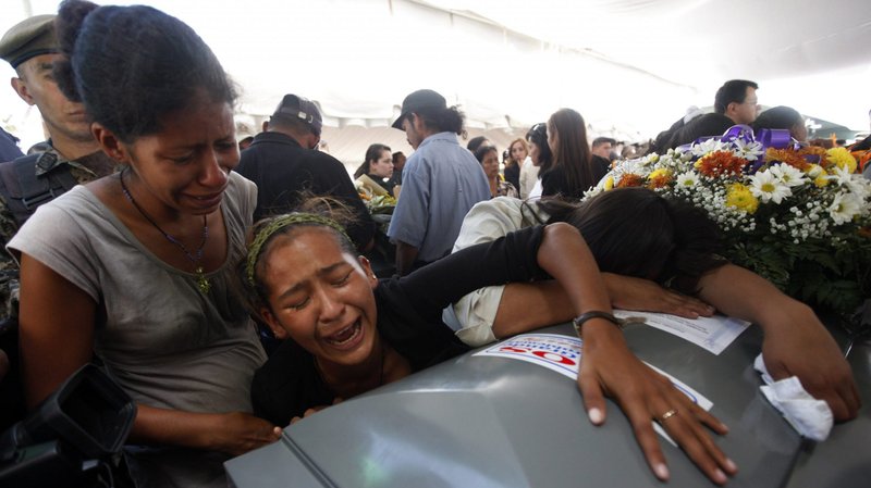 Relatives of Miguel Carcamo, one of the 21 Hondurans who were among the 72 migrants murdered in Mexico, cry on his coffin during an official ceremony in Tegucigalpa, Honduras, Sept. 1, 2010. Mexican marines found 72 corpses at a remote ranch near the U.S. border, the Mexican navy said. (CNS photo/Edgard Garrido, Reuters)