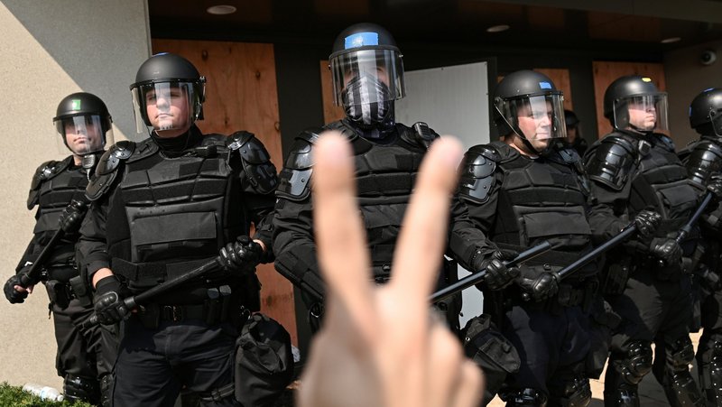 Police in Kenosha, Wis., are confronted with a peace sign during a protest Aug. 24, 2020, over the police shooting of Jacob Blake. Blake, a Black man, was shot seven times in the back the previous day while entering his car with his three small children inside the vehicle. (CNS photo/Stephen Maturen, Reuters)