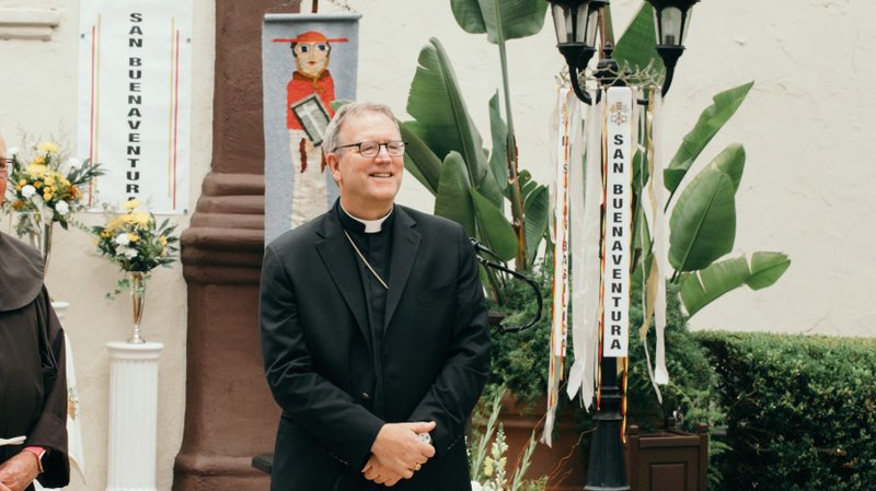 Bishop Robert Barron greets people in the garden of Mission Basilica San Buenaventura before the July 15, 2020 Mass celebrating the mission's papal designation as a minor basilica. (Colton Machado/Archdiocese of Los Angeles)
