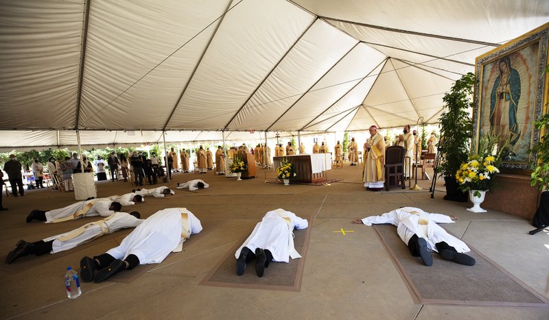 The eight candidates to the priesthood lay prostrate in prayer during the singing of the Litany of the Saints. (Victor Alemán)