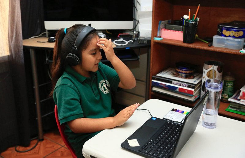2nd grader Maria de la Luz Amador of St. Vincent's School near downtown LA makes the sign of the cross while at home during class last month. (David Amador Rivera)