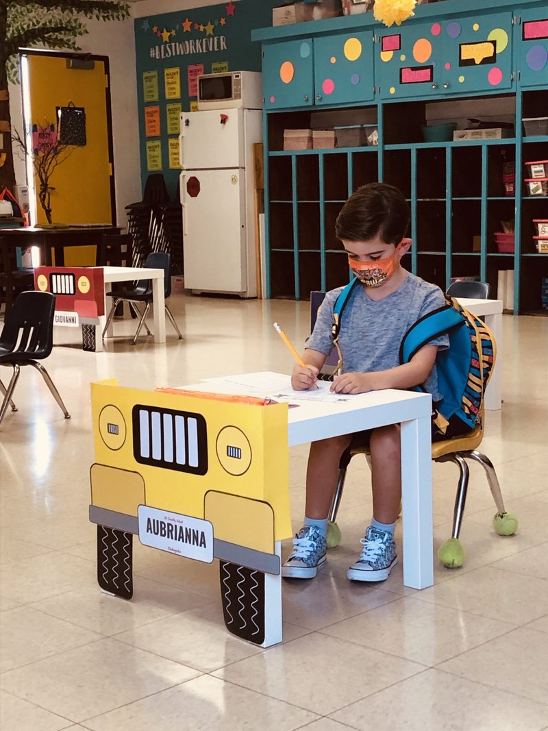A kindergartner sits at a desk during orientation and book pickup at St. Dorothy School in Glendora. (RYAN NEARHOFF)