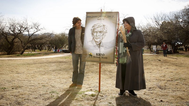 In this 2016 file photo, Carmen Dolny and Rosie Garcia display a banner showing an image of Jesuit Father Eusebio Francisco Kino at the Tumacacori National Historical Park in Tumacacori, Ariz. Often referred to as Padre Kino, the legacy of the 17th century priest was reflected upon during an August 2020 memorial Mass. (CNS photo/Nancy Wiechec)