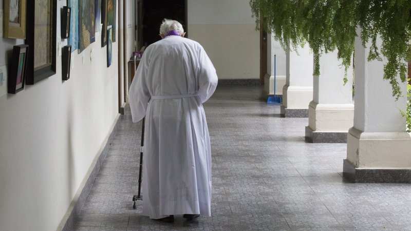 An elderly priest is pictured in a file photo walking to his residence at Our Lady of Carmen Church in Panama City. (CNS photo/Bob Roller)