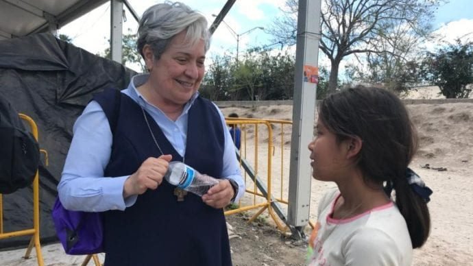 Sister Norma Pimentel, director of Catholic Charities of the Rio Grande Valley in Texas, speaks with a young resident of a tent camp housing some 2,500 asylum seekers in Matamoros, Mexico, Feb. 29, 2020. She leads teams providing support for the camp, which is occupied by people forced to stay on the Mexican side of the border while their asylum claims are heard in U.S. courts. (David Agren/CNS via Crux)