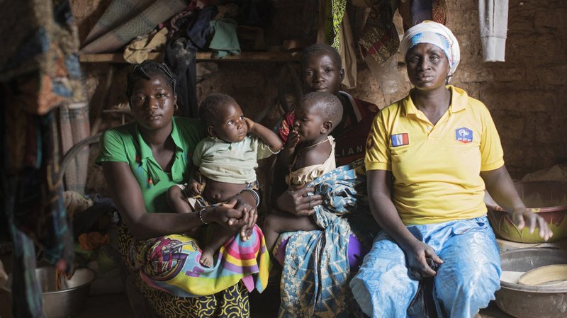A family poses for a photo in mid-March in their home in Kaya, Burkina Faso. Most people in the Sahel region in Africa are poor and lack formal education and skills "that could enable them to ascend social and economic ladders," a report from Catholic Relief Services said. (CNS photo/Julien Ermine, Reuters)