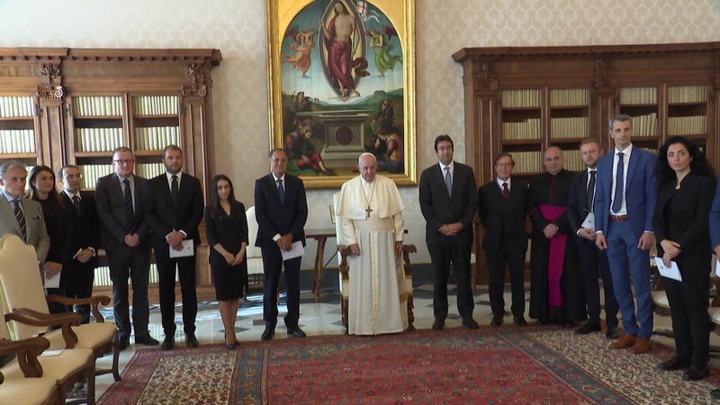 Pope Francis poses with experts from Moneyval, the European financial crime evaluators, during a meeting at the Vatican Oct. 8, 2020, in this still image taken from a video. (CNS photo/Vatican Media via Reuters)