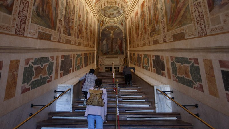 People pray on their knees as they climb the Holy Stairs at the Pontifical Sanctuary of the Holy Stairs in Rome Oct. 8, 2020. The COVID-19 pandemic prevented a grand reopening of the Holy Stairs after a 20-year-long restoration project at the sanctuary. The stairs are believed to have been climbed by Jesus when he appeared before Pilate. (CNS photo/Paul Haring)