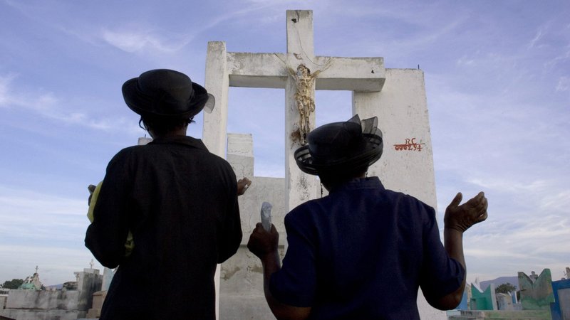 Women are pictured in a file photo praying on All Souls' Day, Nov. 2, at a cemetery in Port-Au-Prince, Haiti. Because of the COVID-19 pandemic response measures restrict most gatherings, the Vatican has extended the usual plenary indulgence to souls in purgatory from just the first week in November to include the entire month. (CNS photo/Eduardo Munoz, Reuters)