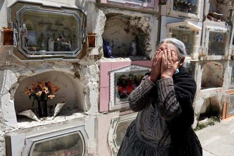 A woman reacts next to the grave of her husband at a cemetery in La Paz, Bolivia, Sept. 24, after the cemetery reopened for visitors during the coronavirus pandemic. (Catholic News Service/David Mercado, Reuters)