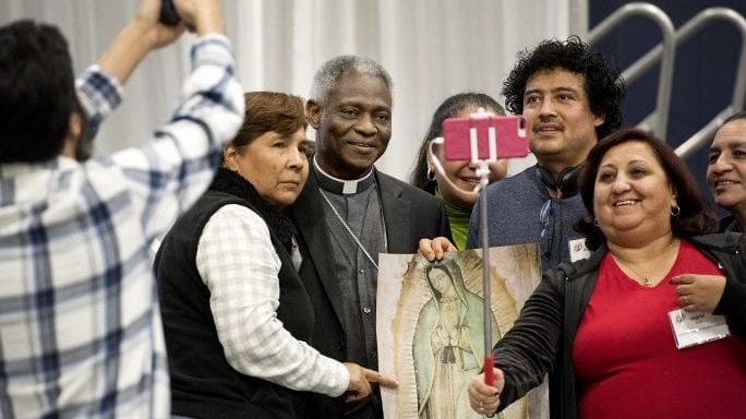 In this file photo, Participants take a group photo with Cardinal Peter Turkson, center, before he delivers the keynote address at the U.S. Regional World Meeting of Popular Movements at Central Catholic High School in Modesto, Calif., Thursday, Feb. 16, 2017. (Andy Alfaro/The Modesto Bee, AP via Crux)