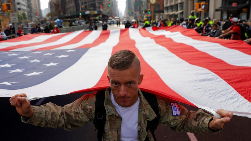 A U.S. Army veteran helps carry the ensign during the Veterans Day Parade in New York City Nov. 11, 2019. (CNS photo/Andrew Kelly, Reuters)