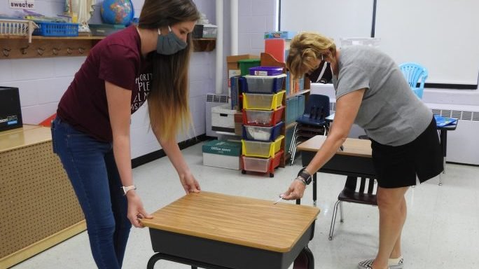 Jessica Westerman, left, a kindergarten teacher at St. Athanasius Catholic School School in Louisville, Ky., and Margie Reece, the school's principal, measure and arrange desks in a classroom July 6, 2020, to provide more space between students in preparation for the new school year. (CNS/Jennifer Jenkins, The Record via Crux)