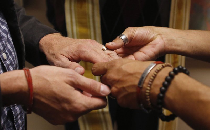 A same-sex couple is pictured in a file photo exchanging rings during a ceremony in Salt Lake City. (Catholic News Service/Jim Urquhar, Reuters)