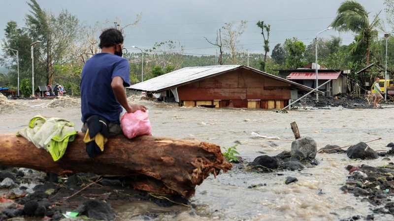 A man looks at his house buried under the pile of rubble and sand in Daraga, Philippines, Nov. 1, 2020, following flash floods brought by Super Typhoon Goni, also known as Rolly. The storm, whose maximum wind speeds earned it the distinction of the year's most powerful cyclone, left at least 10 people dead and three missing. (CNS photo/Nino N. Luces, Reuters)
