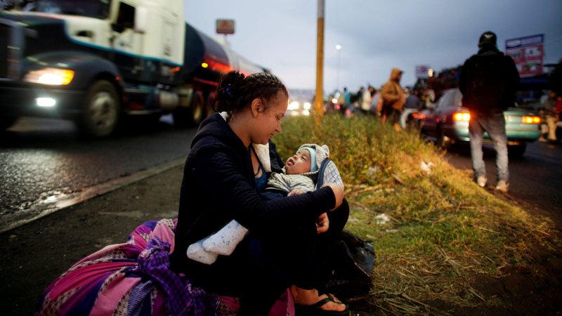 A migrant mother from Honduras plays with her 4-month-old child in Tierra Blanca, Mexico, as they wait for a lift to the United States Jan. 27, 2019. The New York Times first reported Central American migrant children who are in the U.S. are being sent to Mexico in an Oct. 30, 2020, story. (CNS photo/Alexandre Meneghini, Reuters)