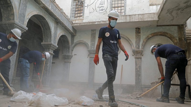 Volunteers in Mosul, Iraq, clean the Syriac Catholic Church of St. Thomas Oct. 28, 2020. News reports said the effort "seeks to sweep away the horrors" of three years of rule by Islamic State militants and welcome back members of minority faiths who fled IS. (CNS photo/Abdullah Rashid, Reuters)