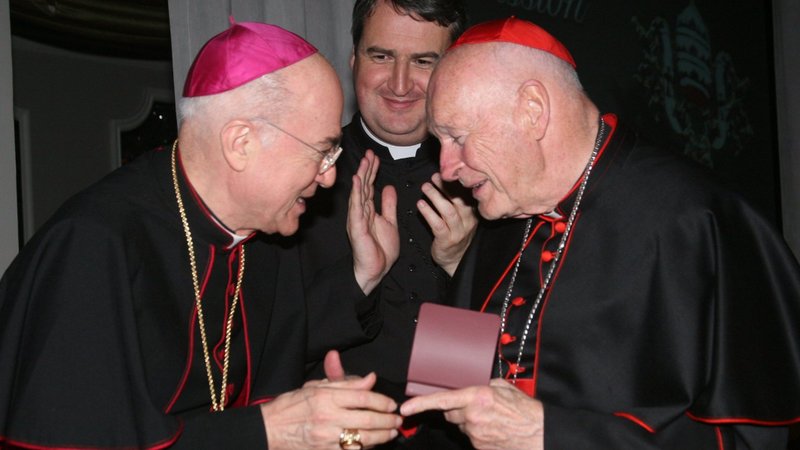 Archbishop Carlo Maria Vigano, nuncio to the United States, congratulates then-Cardinal Theodore E. McCarrick of Washington at a gala dinner sponsored by the Pontifical Missions Societies in New York in May 2012. Archbishop Vigano has since said Cardinal McCarrick already was under sanctions at that time, including being banned from traveling and giving lectures. Oblate Father Andrew Small, center, director of the societies, said Archbishop Vigano never tried to dissuade him from honoring the cardinal at the gala. (CNS photo/Michael Rogel, PMS)
