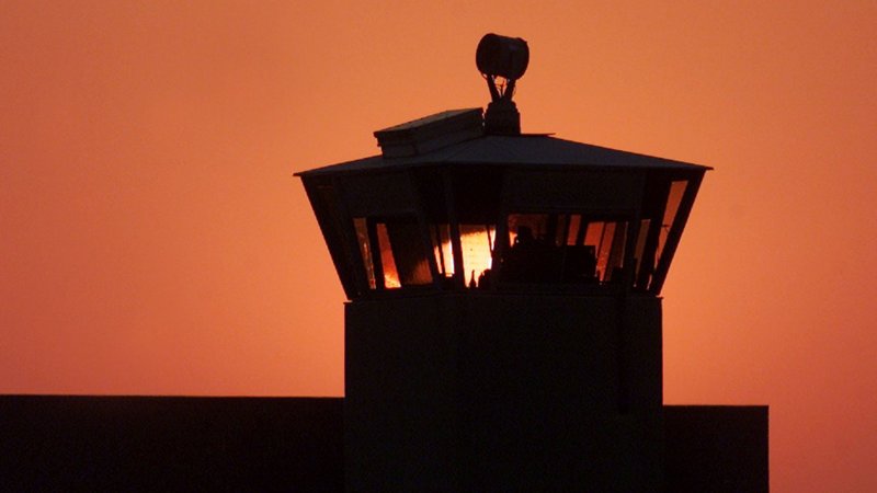 In this file photo, the sun sets behind one of the guard towers at the Federal Correctional Complex in Terre Haute, Ind., June 10, 2001. The death chamber at the correctional facility is where the federal death penalty is carried out. (CNS photo/Andy Clark, Reuters)