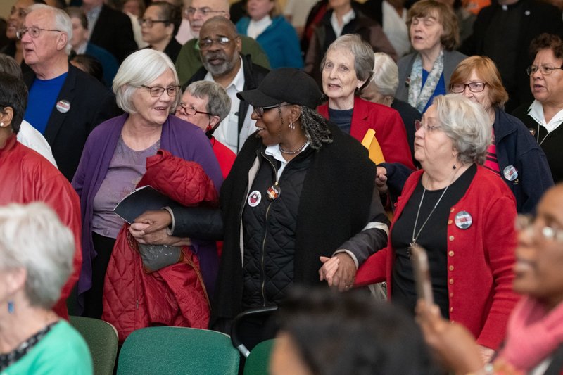 Carol Rice, Deborah Reddy and Joan Stine stand in solidarity during the closing song, "Let there be Peace on Earth," during a listening session on racism at Notre Dame of Maryland University in Baltimore April 29, 2019. (CNS photo/Kevin J. Parks, Catholic Review)