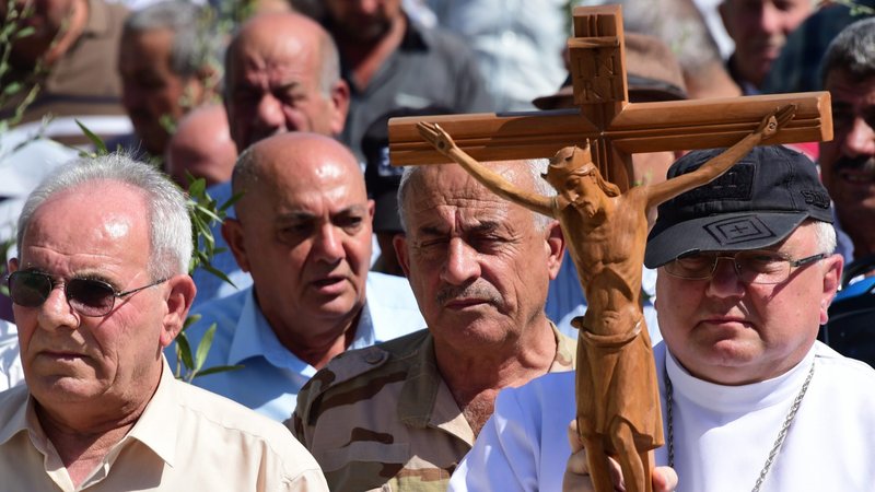 Father Andrzej Halemba is seen in this file photo carrying a crucifix during a procession of the Christians in Qaraqosh, Iraq. (CNS photo/courtesy Aid to the Church in Need)