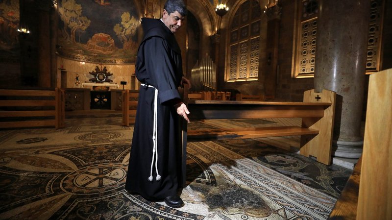 Franciscan Father Ibrahim Faltas from the Custody of the Holy Land inspects the damage to the floor after a man tried to set fire to the Church of the Gethsemane in Jerusalem Dec. 4, 2020. (CNS photo/Ammar Awad, Reuters)