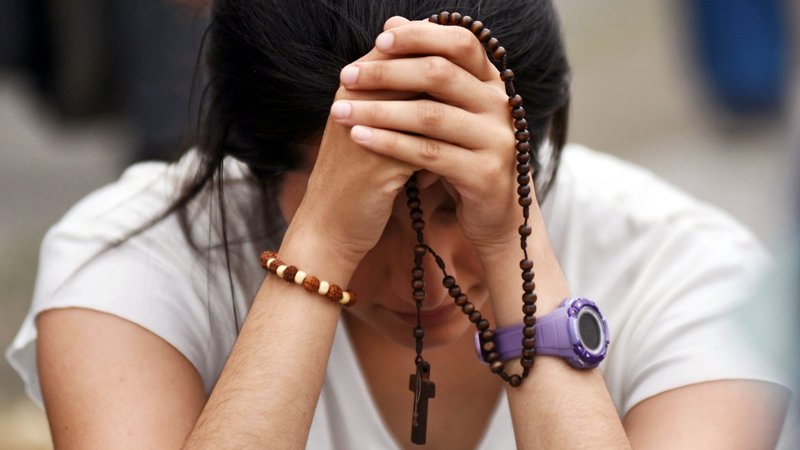 A pro-life supporter prays with a rosary as people protest against legalizing abortion outside the National Congress building in Buenos Aires, Argentina, Dec. 11, 2020. The Chamber of Deputies passed a bill that would permit abortion during the first 14 weeks of pregnancy and allow it at any time for health reasons or in the case of rape. The legislation now heads to the Senate. (CNS photo/Martin Villar, Reuters)
