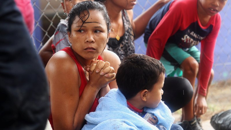 Venezuelan migrants warm themselves after arriving on shore at Los Iros Beach in Erin, Trinidad and Tobago, Nov. 24, 2020. After a different boat carrying refugees was allegedly denied entry into Trinidad and Tobago and subsequently shipwrecked, Venezuelan bishops said the treatment of migrants fleeing the country constitutes serious human rights violations. (CNS photo/Lincoln Holder, Newsday handout via Reuters)