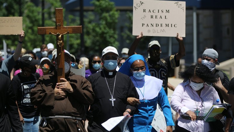 Washington Auxiliary Bishop Roy E. Campbell and a woman religious walk with others toward the National Museum of African American History and Culture in Washington during a peaceful protest June 8, 2020, following the death of George Floyd, an unarmed Black man in Minneapolis whose neck was pinned to the ground by a white police officer for more than eight minutes before he was taken to the hospital. (CNS photo/Bob Roller)