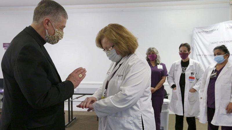 Cardinal Blase J. Cupich of Chicago blesses employees at St. Anthony Hospital who distribute the COVID-19 vaccine Dec. 23, 2020. (CNS photo/Karen Callaway, Chicago Catholic)