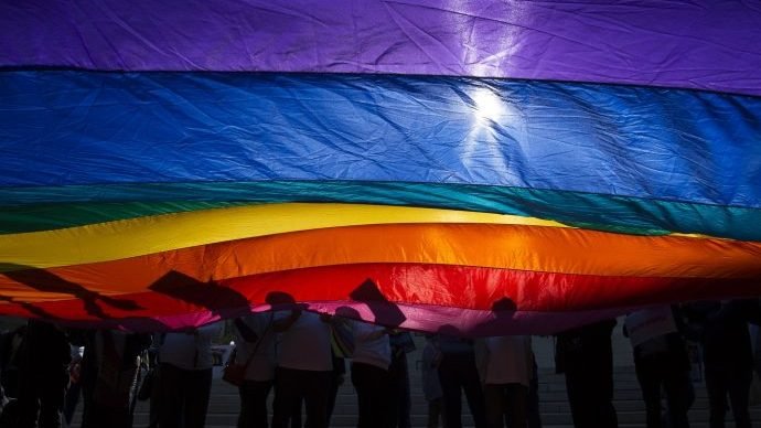 In this 2015 file photo, LGBTQ supporters wave a flag outside the U.S. Supreme Court in Washington. The court ruled June 15, 2020, that federal anti-discrimination laws protect gay and transgender employees from discrimination. (Tyler Orsburn/CNS via Crux)