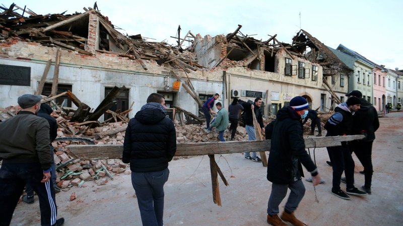 People clean debris after an earthquake in Petrinja, Croatia, Dec. 29, 2020. (CNS photo/Antonio Bronic, Reuters)