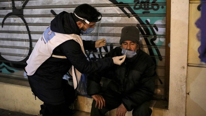A health care worker takes a swab from a homeless man for a rapid antigen COVID-19 test in Athens, Greece, Dec. 21, 2020. In his message for the Feb. 11 celebration of the World Day of the Sick, Pope Francis called on Christians to practice what they preach, including by guaranteeing equal access to health care for all people. (CNS photo/Costas Baltas, Reuters)