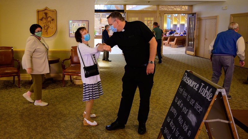 Father Peter Ambting, pastor of Our Lady of Lourdes Parish in De Pere, Wis., greets a parishioner before Mass in this June 14, 2020, file photo. Pope Francis, in his message for World Mission Sunday, said that during the pandemic there is an "urgent need for the mission of compassion." (CNS photo/Sam Lucero, The Compass)