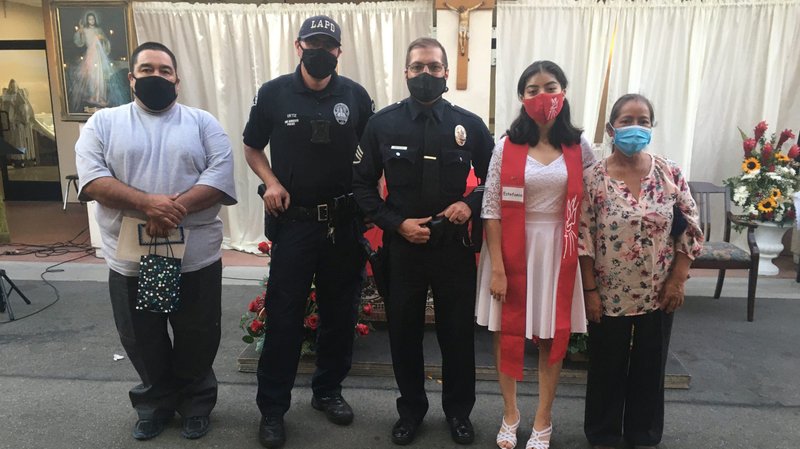 Estefiana Torres, second from right, at her Sept. 18 confirmation ceremony at St. Lawrence of Brindisi Church in Watts. From left: Her father, Luis Torres; LAPD officers Eric Ortiz and Ken Busiere, and Estefiana’s mother, Francisca Arenas, far right. (Father Matt Elshoff)