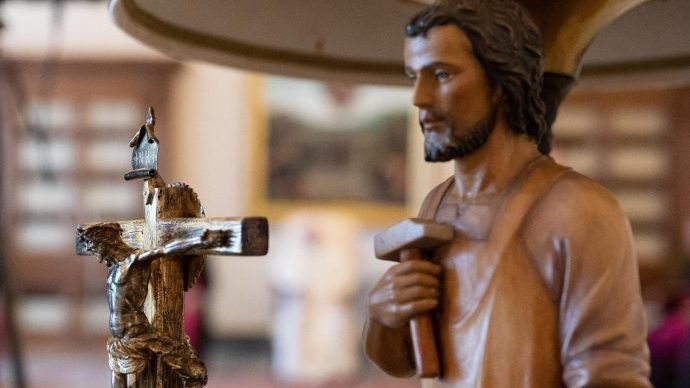 A crucifix and a statue of St. Joseph are seen as Pope Francis leads his general audience in the library of the Apostolic Palace at the Vatican Aug. 26, 2020. Christians cannot stand idly by and watch as milions of people are deprived of their basic needs because of greed, the pope said. (CNS photo/Vatican Media via Crux)