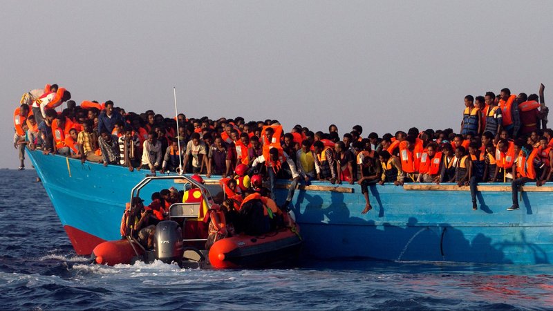 A rescue boat of the Spanish NGO Proactiva approaches an overcrowded wooden vessel with migrants from Eritrea, off the Libyan coast in the Mediterranean Sea Aug. 29, 2016. Many Eritreans fled across the sea or to Ethiopia to escape political persecution, compulsory military service and war back home. (CNS photo/Giorgos Moutafis, Reuters)