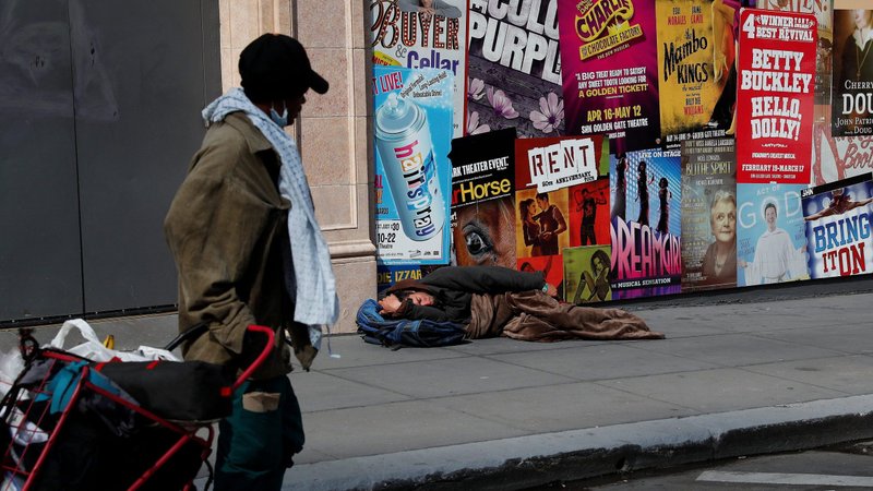 A man in San Francisco sleeps on the sidewalk March 27, 2020, amid the coronavirus pandemic. (CNS photo/Shannon Stapleton, Reuters)