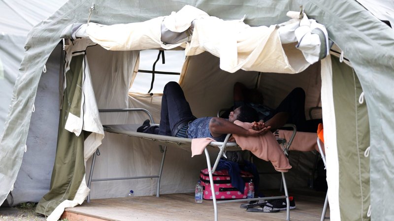 A refugee rests in a tent set up by the Canadian Armed Forces near the U.S.-Canadian border in Lacolle, Quebec Aug. 10, 2017. (CNS photo/Christinne Muschi, Reuters)