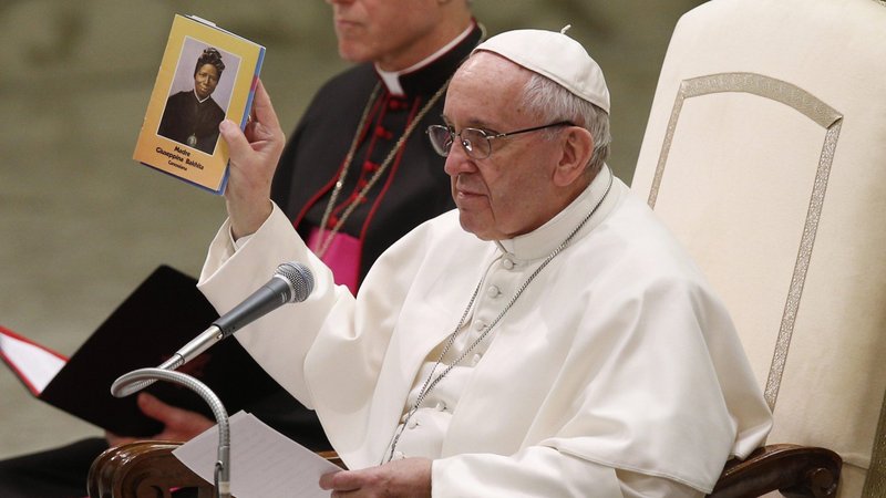 Pope Francis holds a booklet with an image of St. Josephine Bakhita, who was sold into slavery as a child, during his general audience at the Vatican in this Feb. 8, 2017, file photo. The pope released a video message marking the International Day of Prayer and Awareness against Human Trafficking, which is celebrated on the Feb. 8 feast of St. Bakhita. (CNS photo/Paul Haring)
