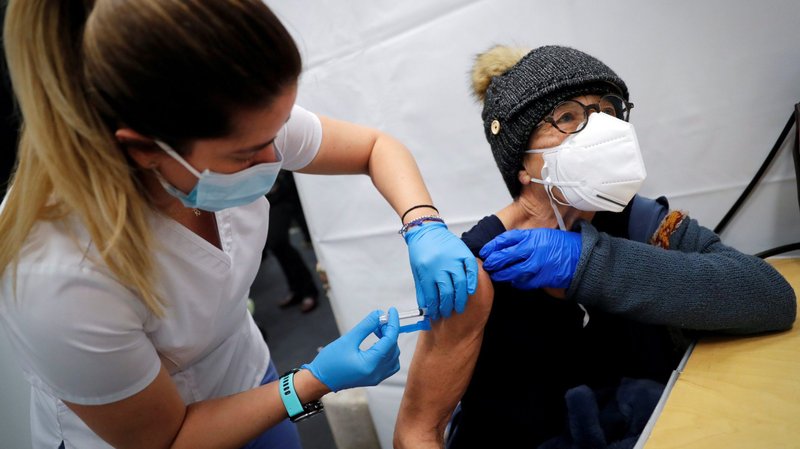A health care worker in New York City administers a shot of the Moderna COVID-19 vaccine to a woman at a pop-up vaccination site Jan. 29, 2021. (CNS photo/Mike Segar, Reuters)