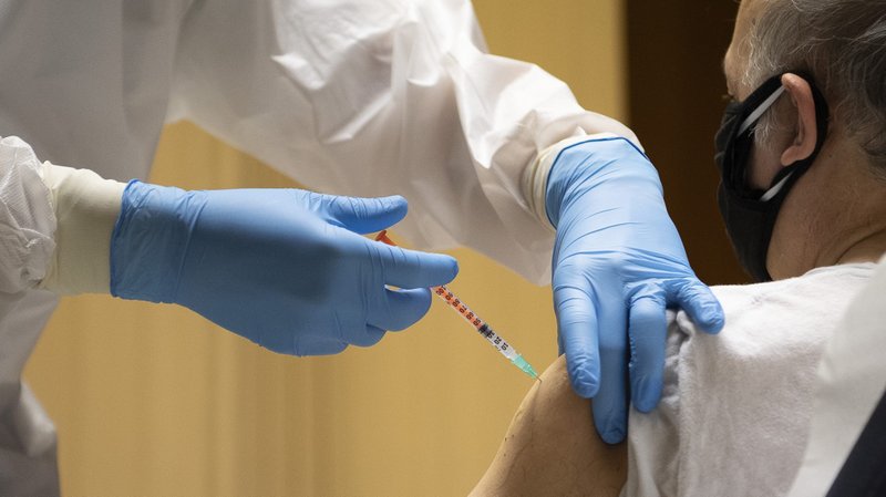 A man receives the first dose of the COVID-19 vaccine in the atrium of the Paul VI hall at the Vatican in this Jan. 20, 2021, file photo. A variety of sanctions have been issued by the head of the commission governing Vatican City State for citizens, residents and personnel who fail to follow current COVID-19 measures. The sanctions cover employees who refuse vaccination. (CNS photo/Vatican Media)