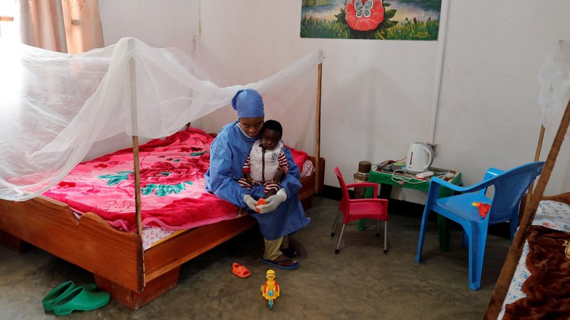 Noella Kavira Kitakya, 26, an Ebola survivor who works as a caregiver, puts a shoe on a child whose mother died of Ebola at a UNICEF center in Katwa, Congo, in this Oct. 2, 2019, file photo. Pope Francis opened a new path to sainthood in 2017 for "martyrs of charity," those who made heroic sacrifices during pandemics and other situations of contagion. (CNS photo/Zohra Bensemra, Reuters)