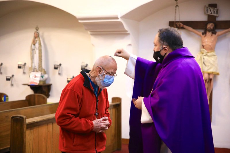 Fr. Domingos Machado, O.A.R., distributes ashes at Cristo Rey Church in Atwater Village Feb. 17. (David Amador Rivera)