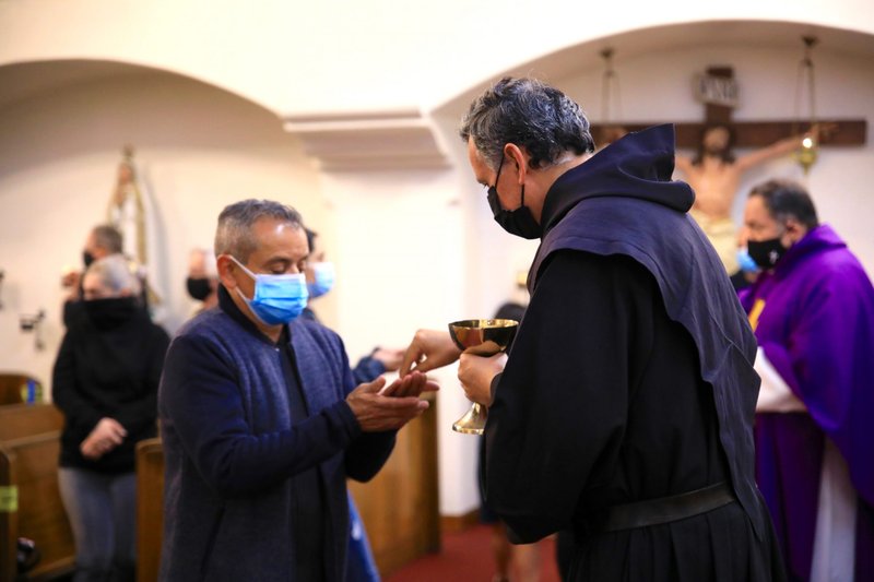 Fr. Jorge Matos, O.A.R., distributes communion at Ash Wednesday Mass at Cristo Rey Church in Atwater Village Feb. 17. (David Amador Rivera)