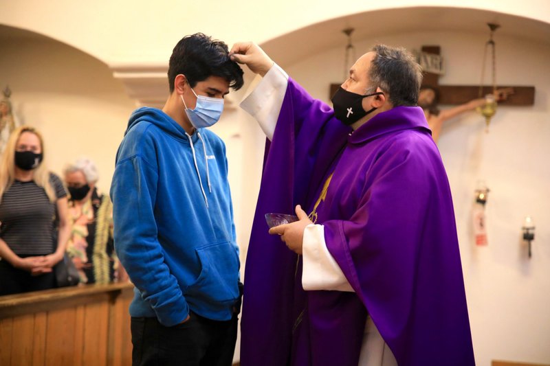 Fr. Domingos Machado, O.A.R., distributes ashes at Cristo Rey Church in Atwater Village Feb. 17. (David Amador Rivera)