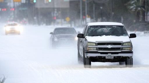 Vehicles drive on snow and sleet covered roads Monday, Feb. 15, 2021, in Spring, Texas. A winter storm dropping snow and ice sent temperatures plunging across the southern Plains, prompting a power emergency in Texas a day after conditions canceled flights and impacted traffic across large swaths of the U.S. (David J Phillip/AP via Crux)