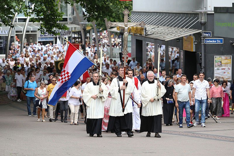 The May 31, 2018 Corpus Christi procession stops at the central Protestant church in Essen, Germany. During the procession Bishop Franz-Josef Overbeck of Essen offered support for allowing a Protestant married to a Catholic to receive Communion as a sign of Christian unity. (CNS photo/Nicole Cronauge, courtesy Diocese of Essen)