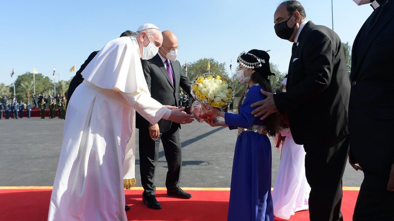 Pope Francis receives flowers from children during a welcoming ceremony with Iraqi President Barham Salih at the presidential palace in Baghdad March 5, 2021. (CNS photo/Vatican Media)
