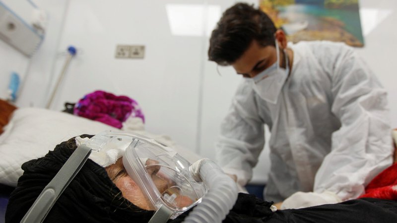 A health care worker checks on a woman infected COVID-19 at the quarantine ward of a hospital in Najaf, Iraq, Feb. 25, 2021. Cardinal Leonardo Sandri, prefect of the Congregation for Eastern Churches, said Christians in the Middle East need the support of Catholics worldwide to overcome difficulties brought on by the COVID-19 pandemic. (CNS photo/Alaa Al-Marjani, Reuters)